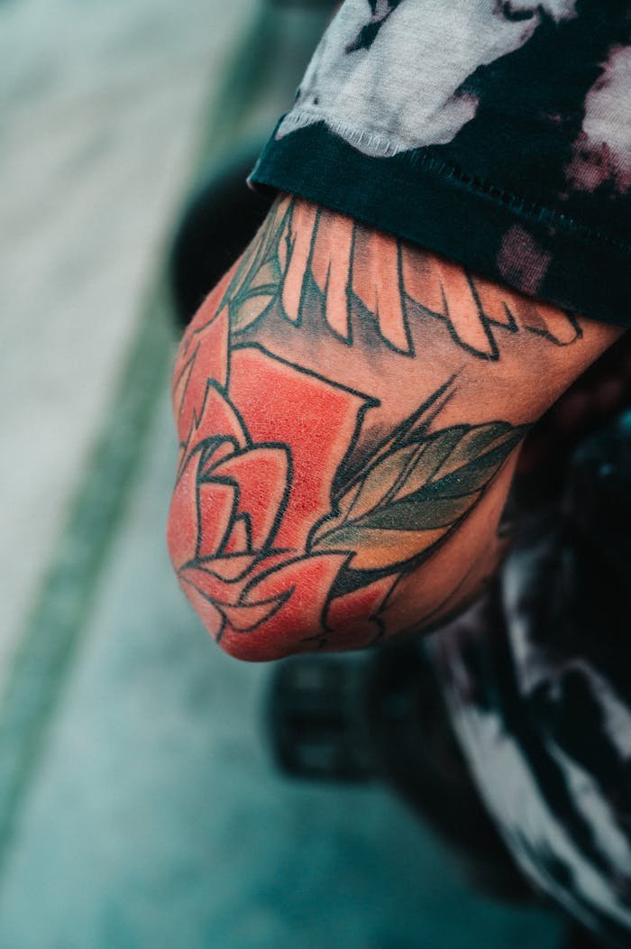 services-03 A detailed view of a colorful floral tattoo on an arm, showcasing artistic design.